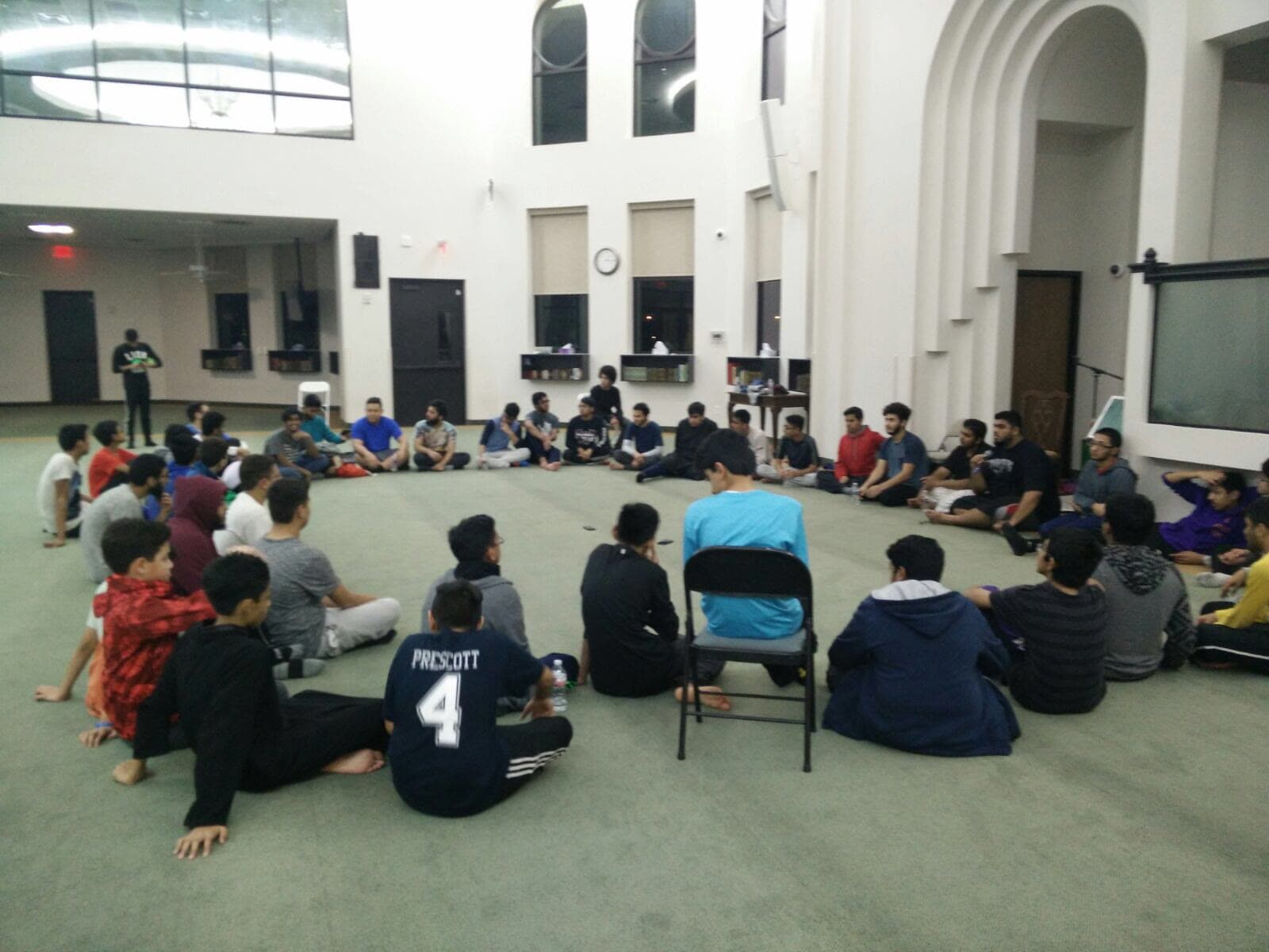 Students seated in a circle on the floor during a session