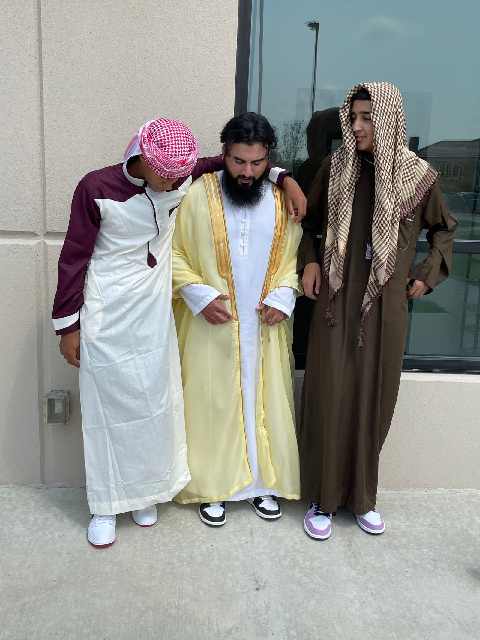 Irslan standing outside with two of his students
